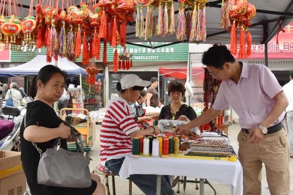 老龙眼96菜市场门囗，有位巧手编织的女艺人 火啦