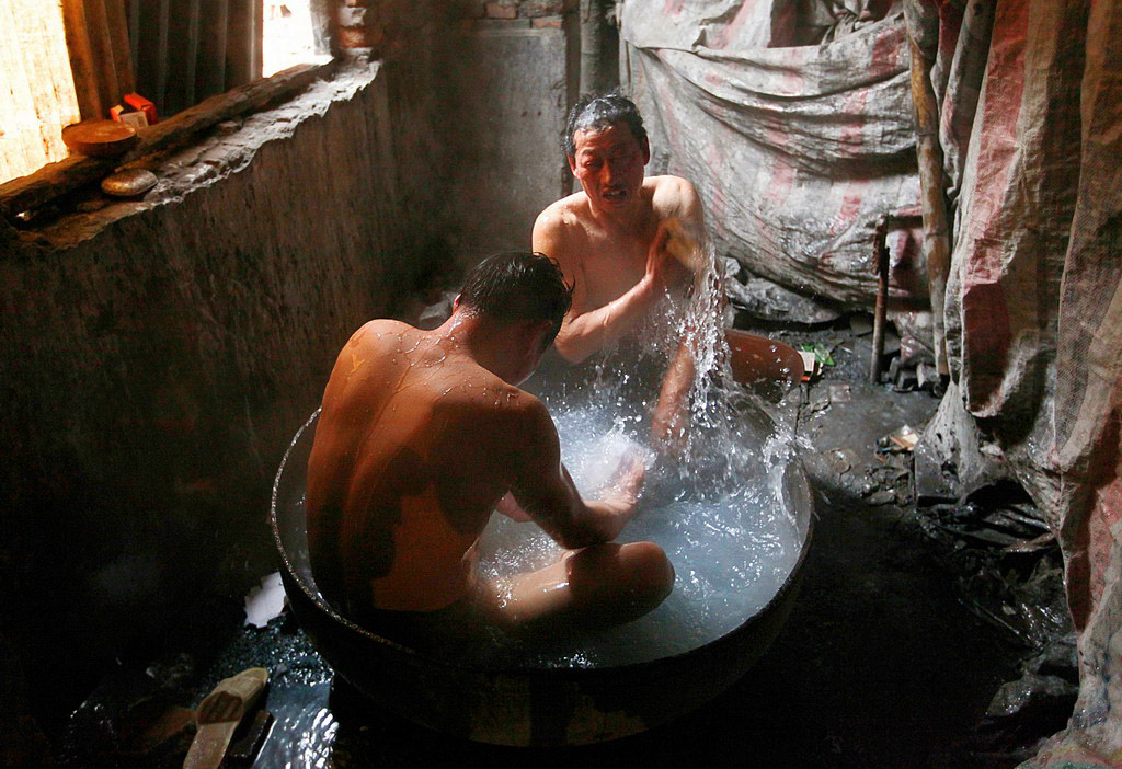在大锅洗澡的农民工